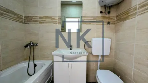 Bathroom equipped with a bathtub, a vanity with a sink, and a toilet. - image 9