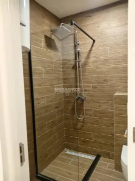 Kupatilo sa tuš kabinom obloženom pločicama u dezenu drveta. - image 14
