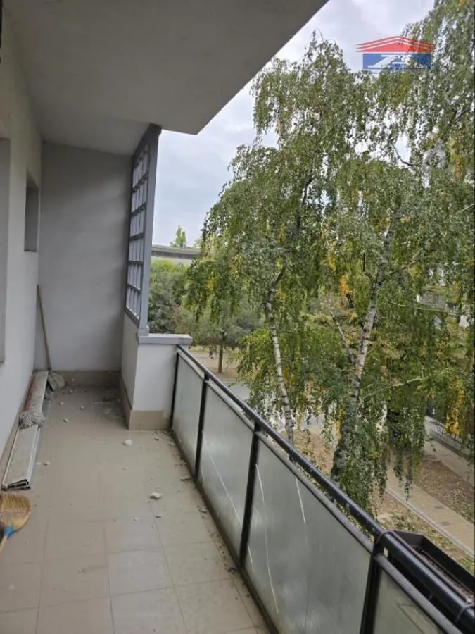 Balcony with a view of trees and surrounding greenery.