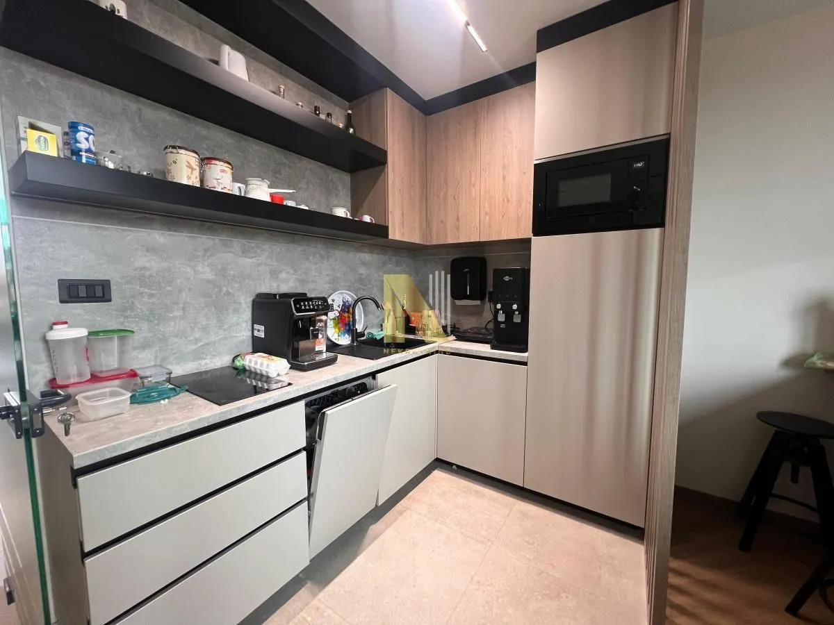 Modern corner kitchen with built-in appliances and shelving.