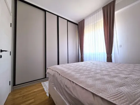Spavaća soba sa velikim bračnim krevetom, garderoberom i prozorom sa zavjesama. - image 13