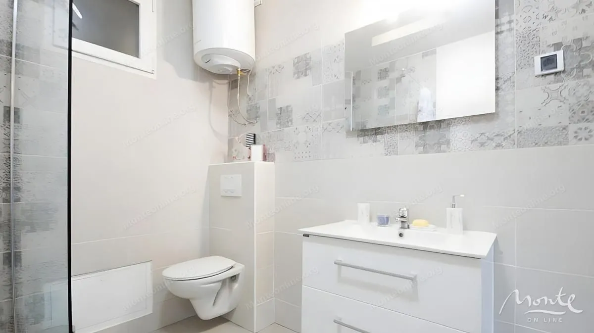 Moderne kupatilo sa tuš kabinom, umivaonikom i wc šoljom.