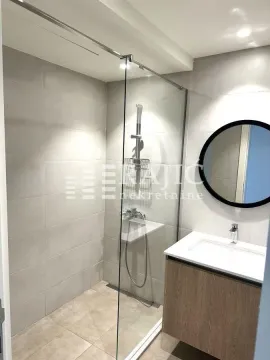 Moderno opremljeno kupatilo sa tuš kabinom i umivaonikom. - image 7