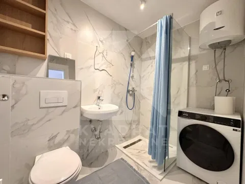 Kupatilo opremljeno tuš kabinom, umivaonikom, WC šoljom i mašinom za veš. - image 8