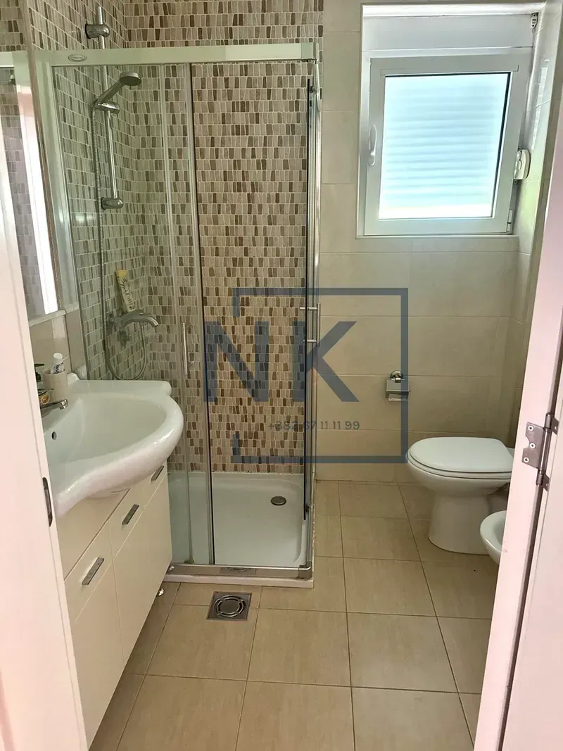 Bathroom equipped with a shower cabin, washbasin, and toilet.