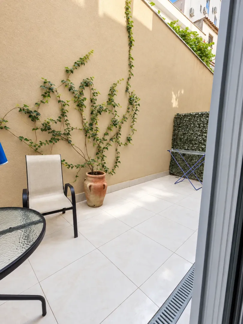 Smaller paved terrace with outdoor seating and decorative plants.
