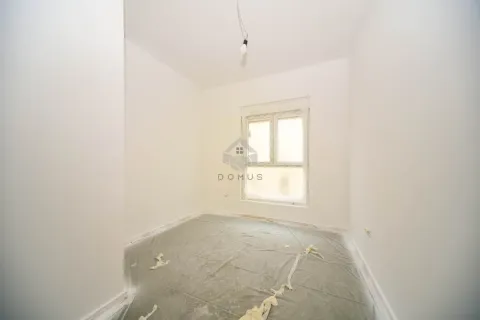 Empty unfinished room with white walls and a window covered in plastic sheeting. - image 13