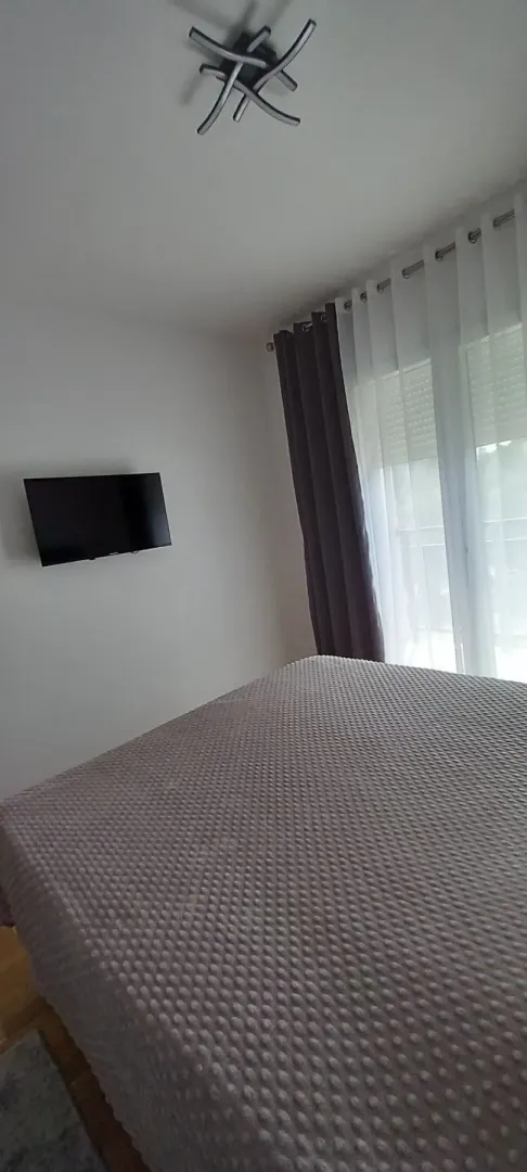 Bedroom with a bed and wall-mounted TV.