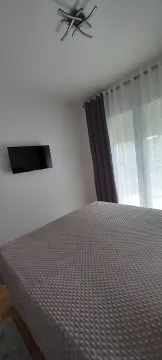 Bedroom with a bed and wall-mounted TV. - image 15