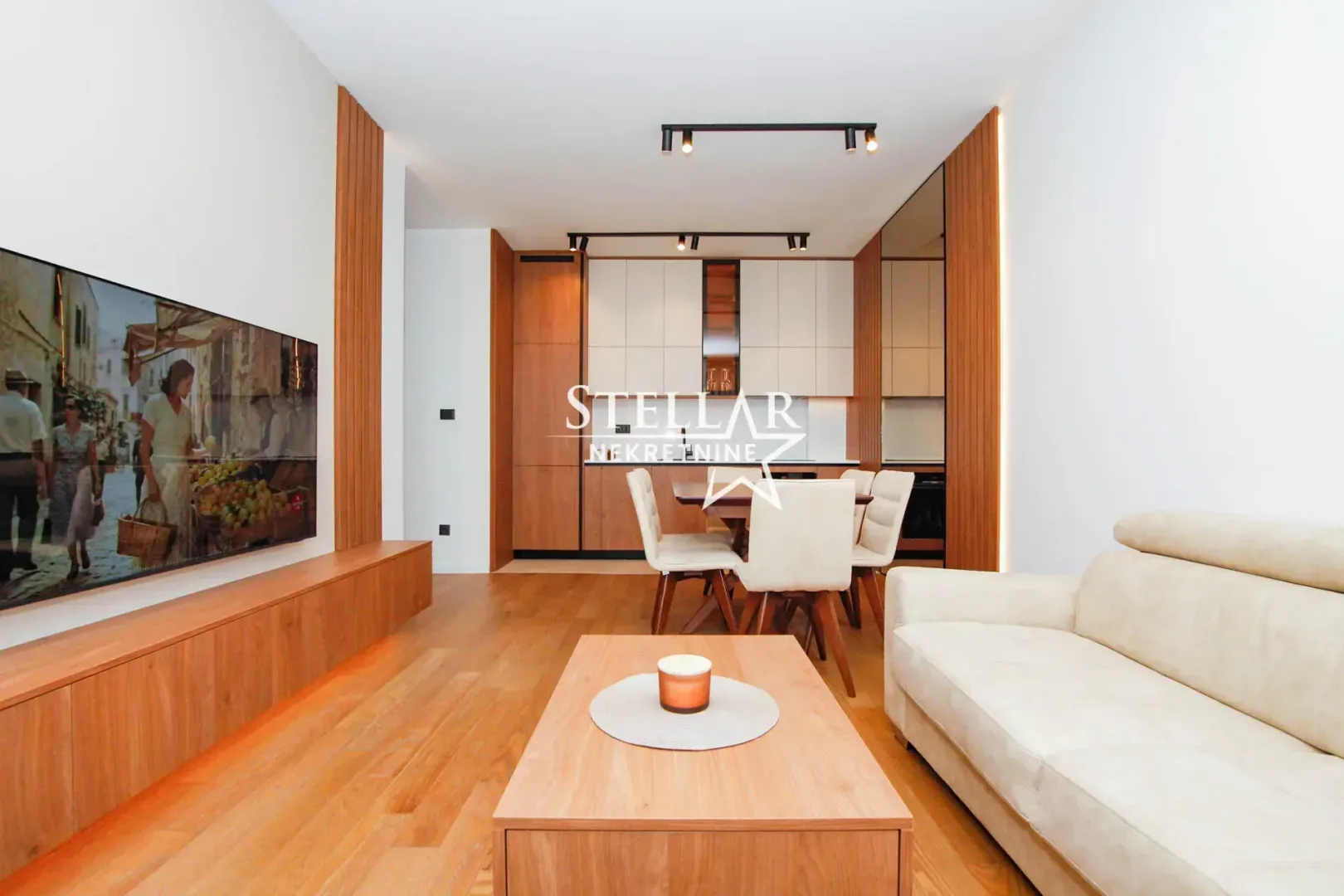 Living room with a sofa, TV, and an adjoining dining area.