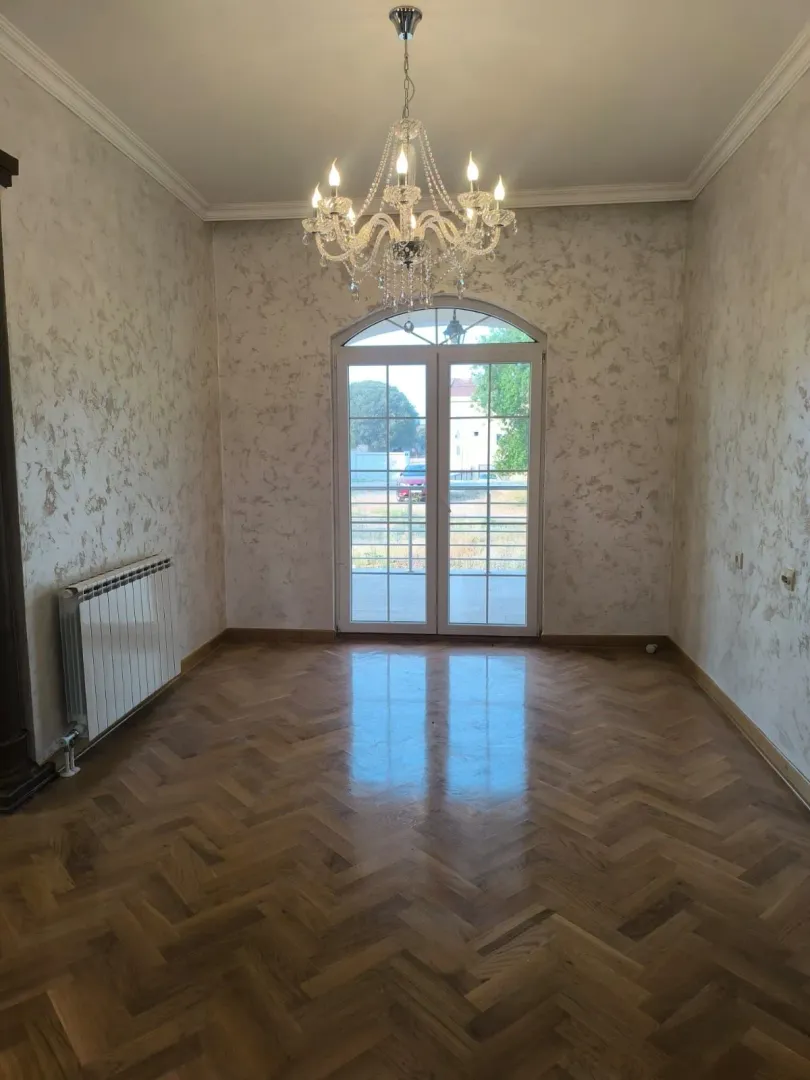 Empty room with parquet flooring, a chandelier, and glass balcony doors.