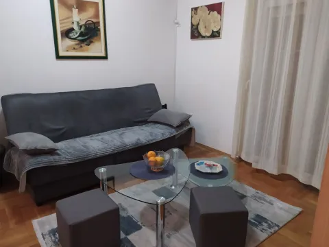 Living room featuring a grey sofa, a glass coffee table, and art pieces on the wall. - image 9