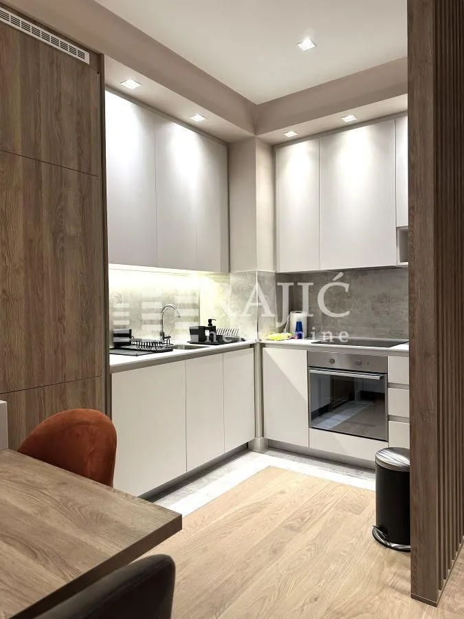 Modern and equipped kitchen with white cabinets and wood paneling.