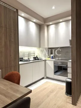 Modern and equipped kitchen with white cabinets and wood paneling. - image 5