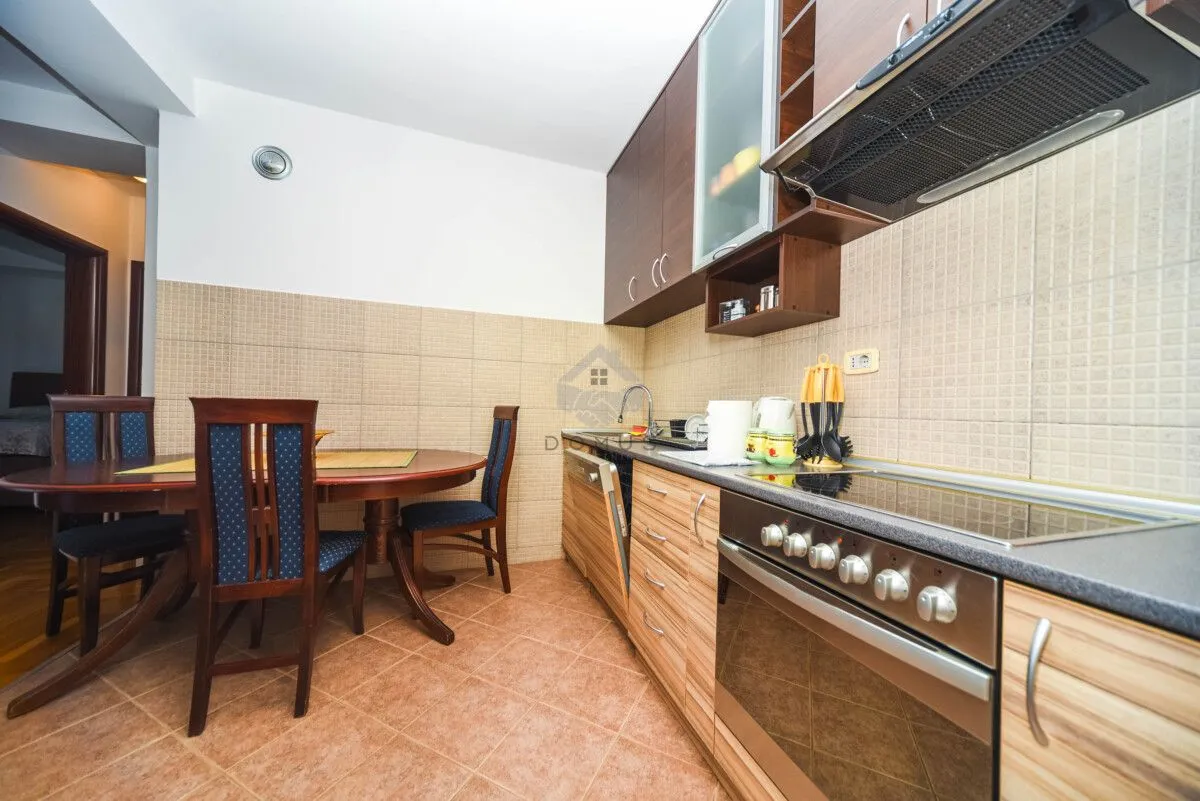 Kitchen with dining area equipped with wooden cabinets and built-in appliances.