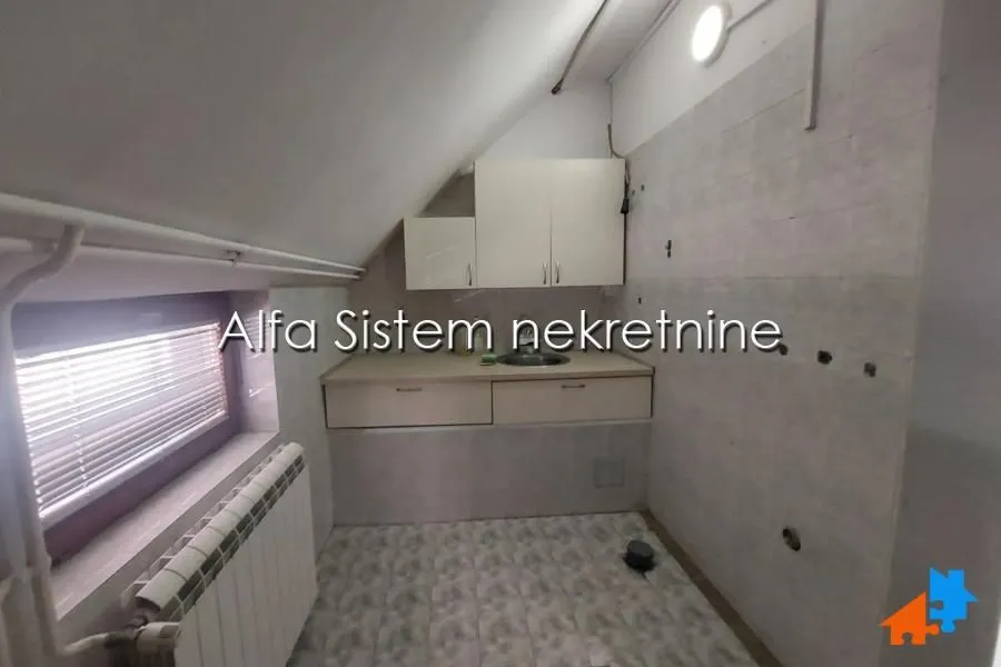 Smaller kitchen located in the attic with a sink and wall cabinets.