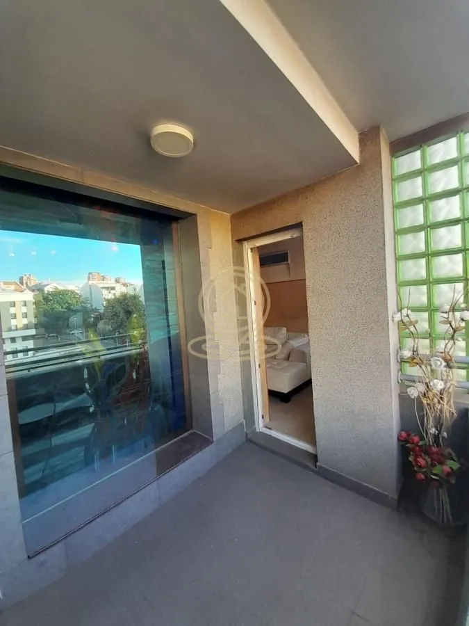 Covered balcony with city view and entrance to the apartment.