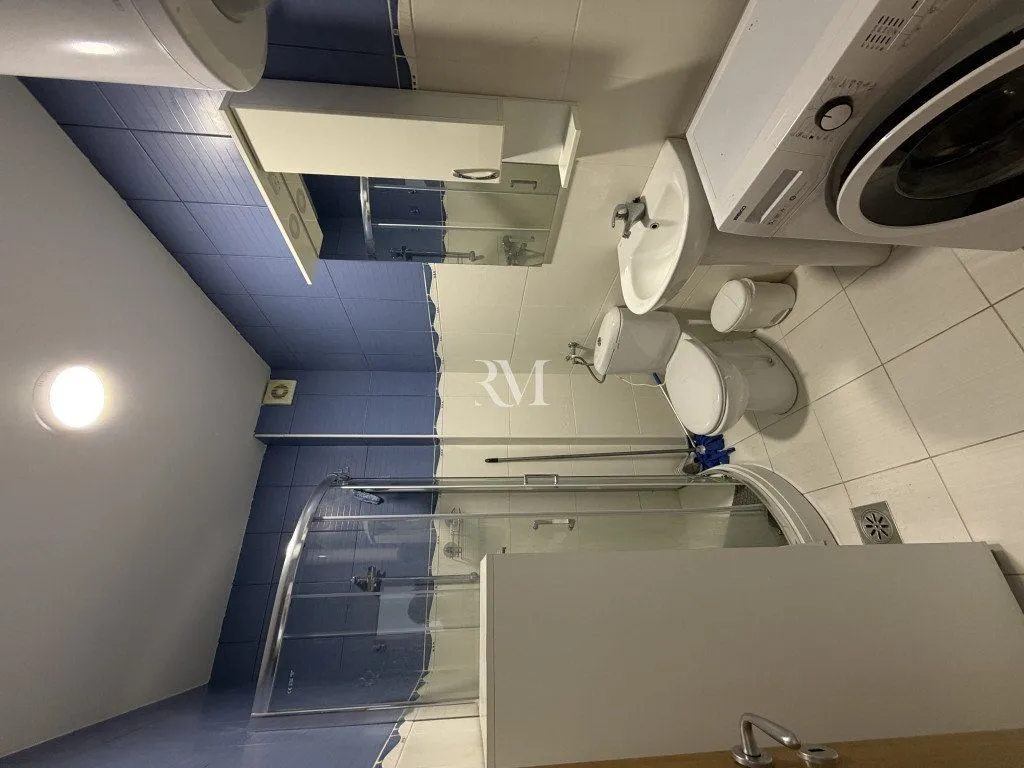 Kompaktno kupatilo sa tuš kabinom, umivaonikom, wc šoljom i veš mašinom.