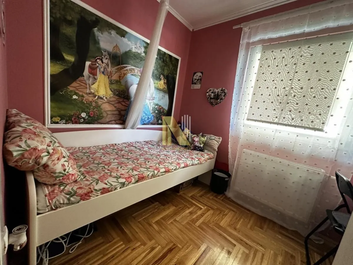 Dečja spavaća soba sa krevetom i tapetom sa motivom bajke.