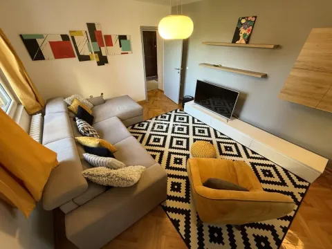 Living room with a sofa, armchair, and television. - image 4