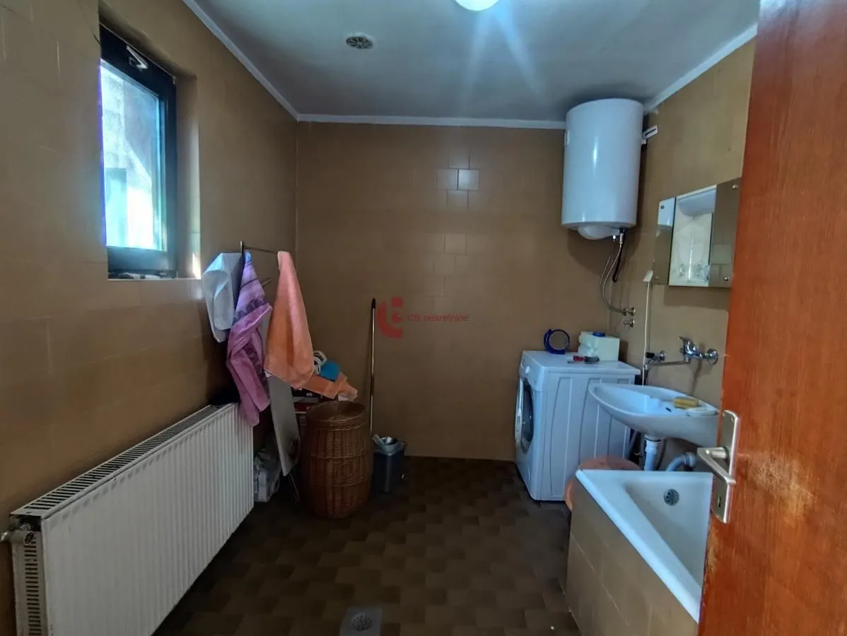 Kupatilo sa kadom, umivaonikom, veš mašinom i bojlerom.