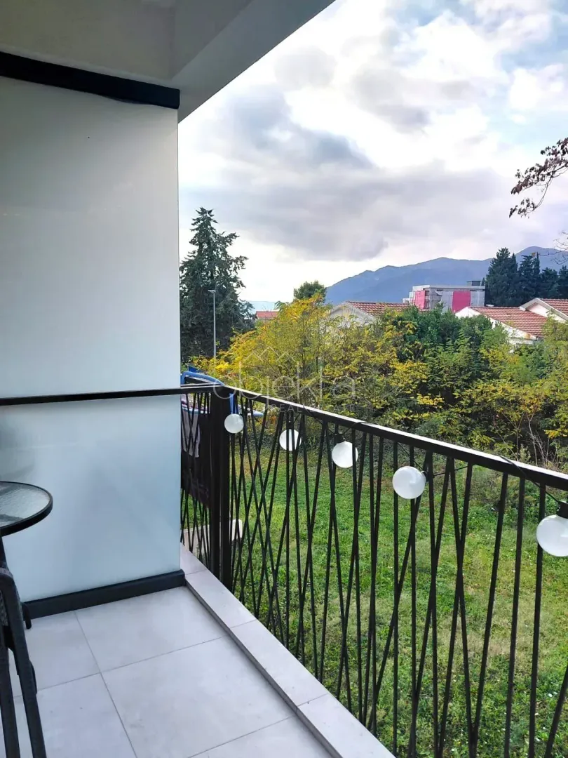 Natkriveni balkon sa pogledom na zelenilo i okolne planine.