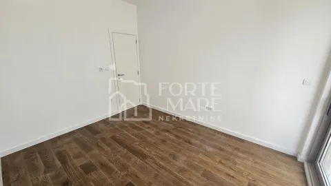 Prazna soba sa bijelim zidovima i drvenim podom. - image 6