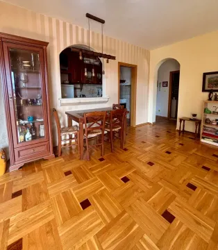 Living room with a dining area and parquet flooring. - image 2