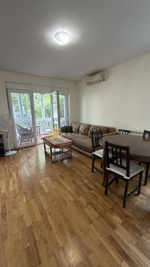 Living room with a sofa, dining table, and access to the terrace.