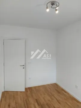 Prazna soba sa belim zidovima, parketom i belim vratima. - image 6