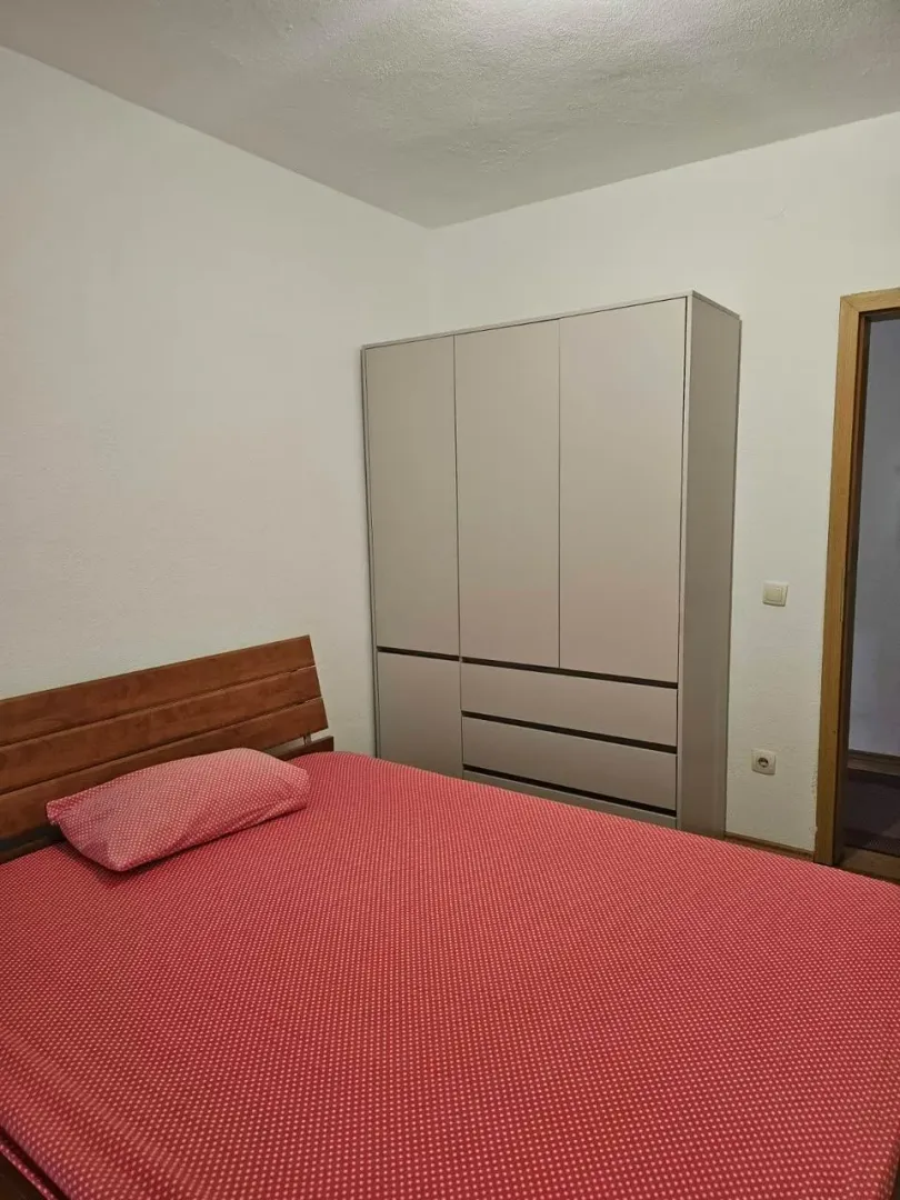 Namještena spavaća soba sa krevetom i ormarom.