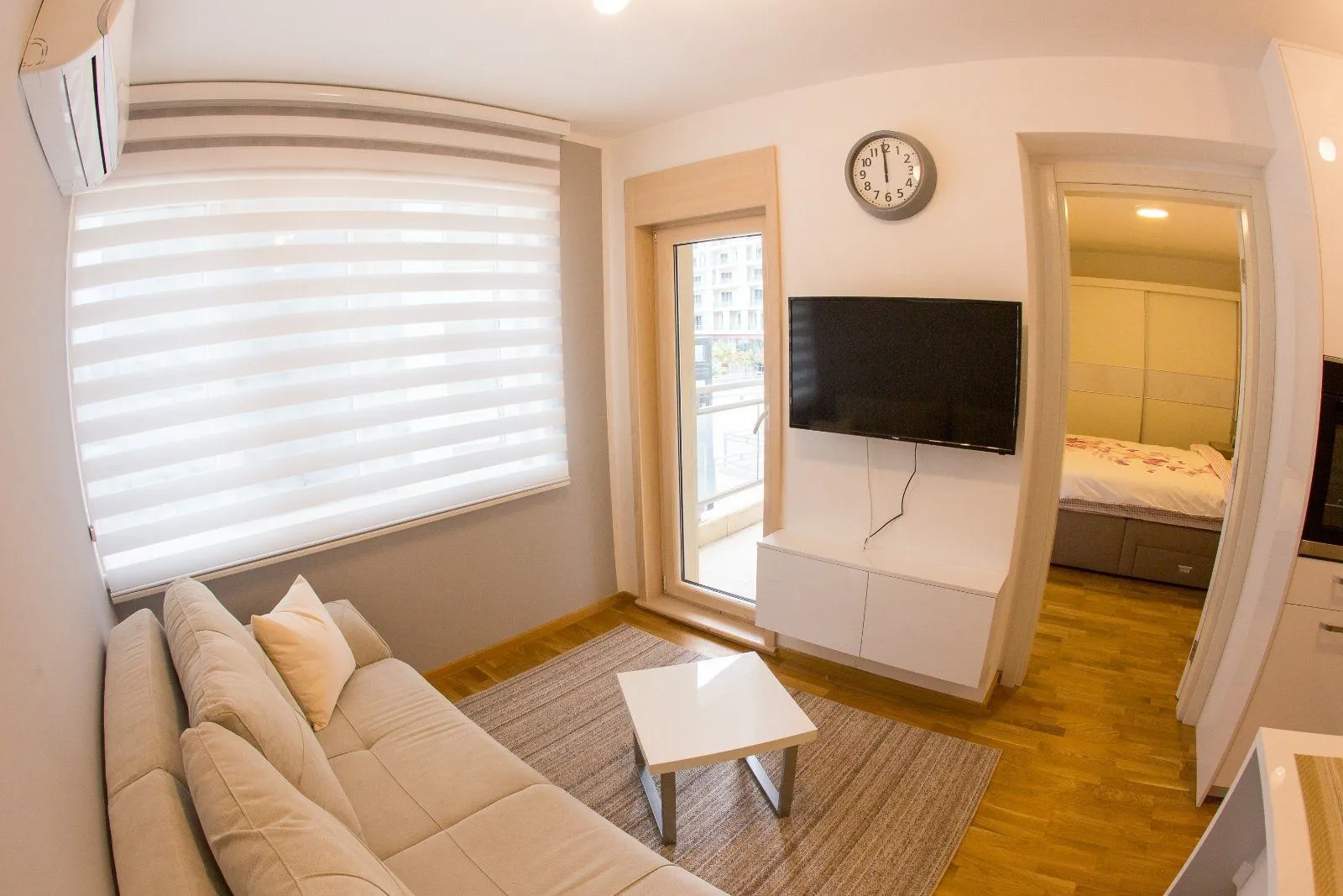 Living room with a sofa, TV and access to the terrace.