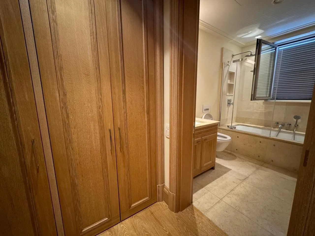 View from the hallway towards the bathroom with wooden elements and a bathtub.