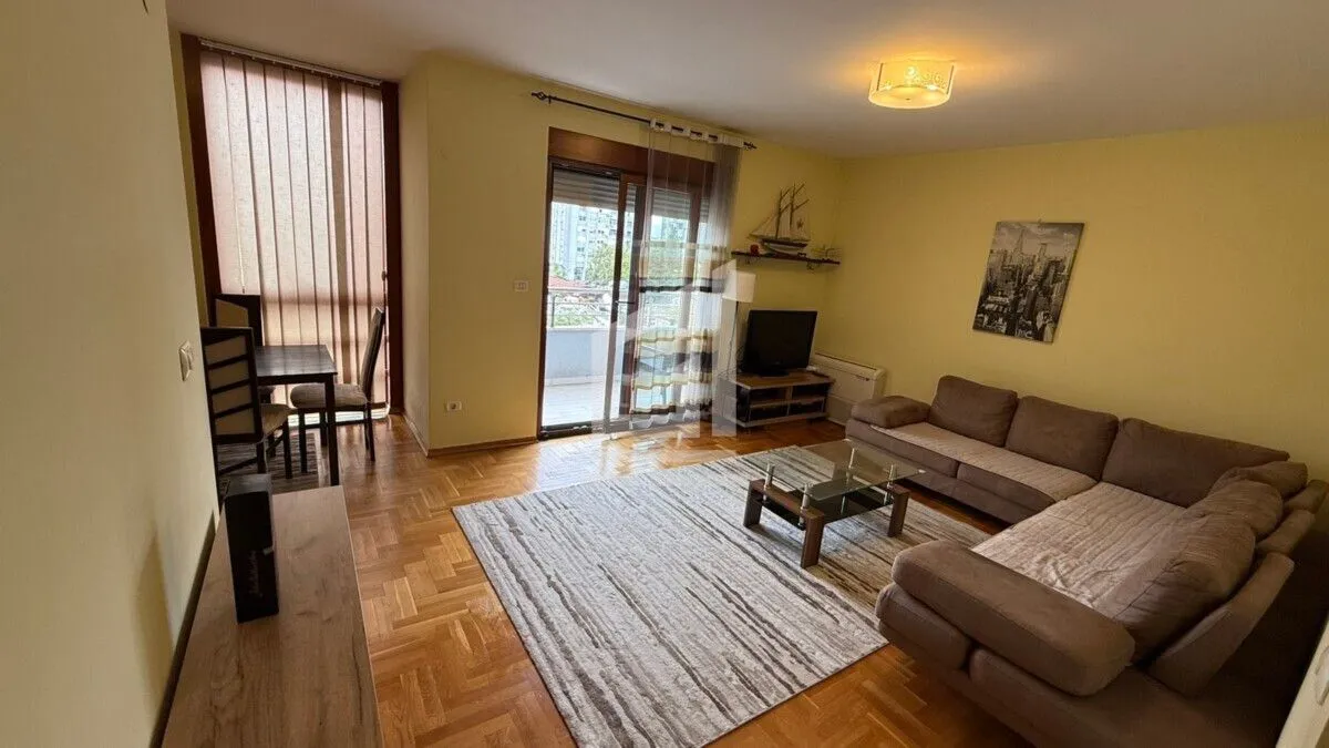Living room with a sofa, TV, and dining table, with access to the terrace.