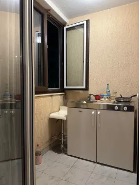 Small kitchen with a sink, stove, and cabinet units. - image 6