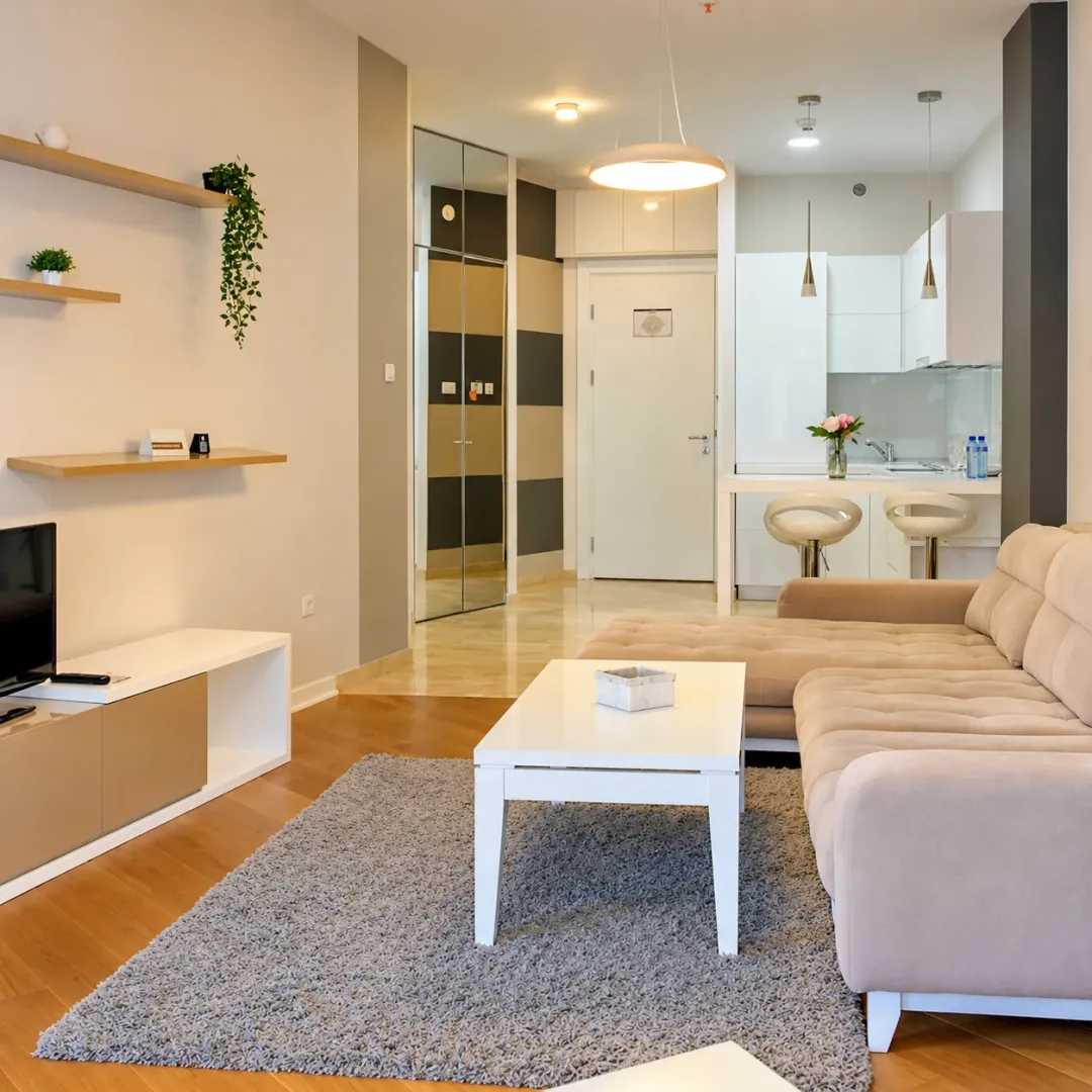 Living room with a sofa, coffee table, and TV, connected to the kitchen.