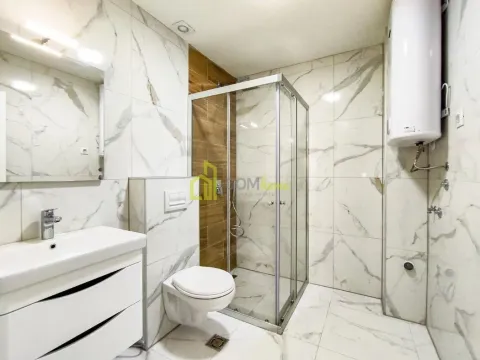 Modernly equipped bathroom with a shower cabin, washbasin, and toilet. - image 9