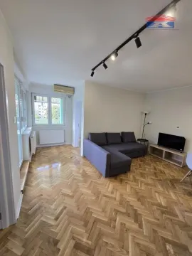 Dnevni boravak sa garniturom za sedenje i parketom na podu. - image 3
