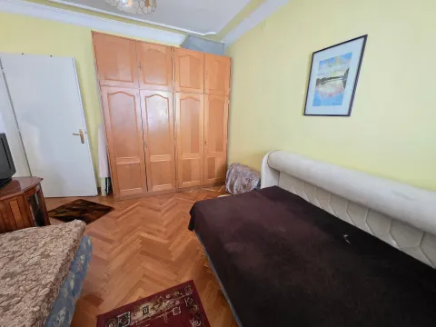 Furnished bedroom with a large wooden wardrobe and a bed. - image 12