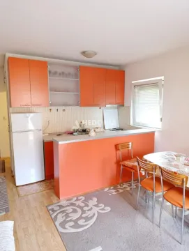 Kitchen with orange cabinets and a dining table. - image 5