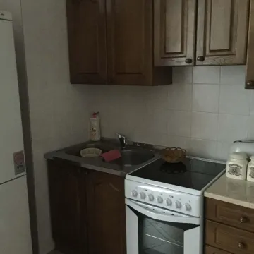 Kuhinja sa klasičnim drvenim elementima, sudoperom i električnim šporetom. - image 3