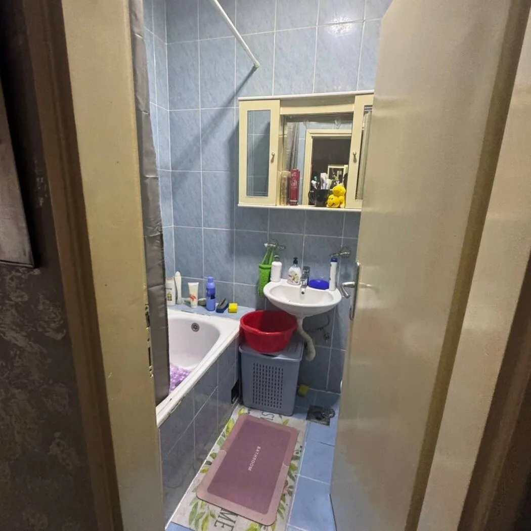 Small bathroom with a bathtub, sink, and wall-mounted mirror cabinet.
