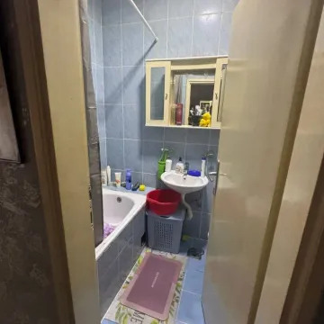 Small bathroom with a bathtub, sink, and wall-mounted mirror cabinet. - image 7