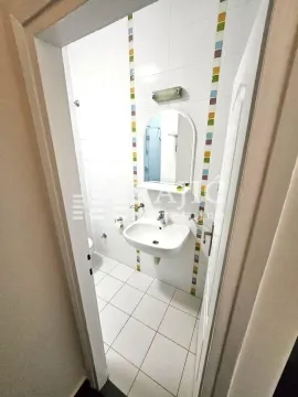 Smaller bathroom with a sink, mirror, and white tiles. - image 16