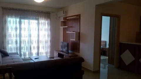 Dnevna soba sa garniturom za sjedenje, televizorom i izlazom na terasu. - image 7