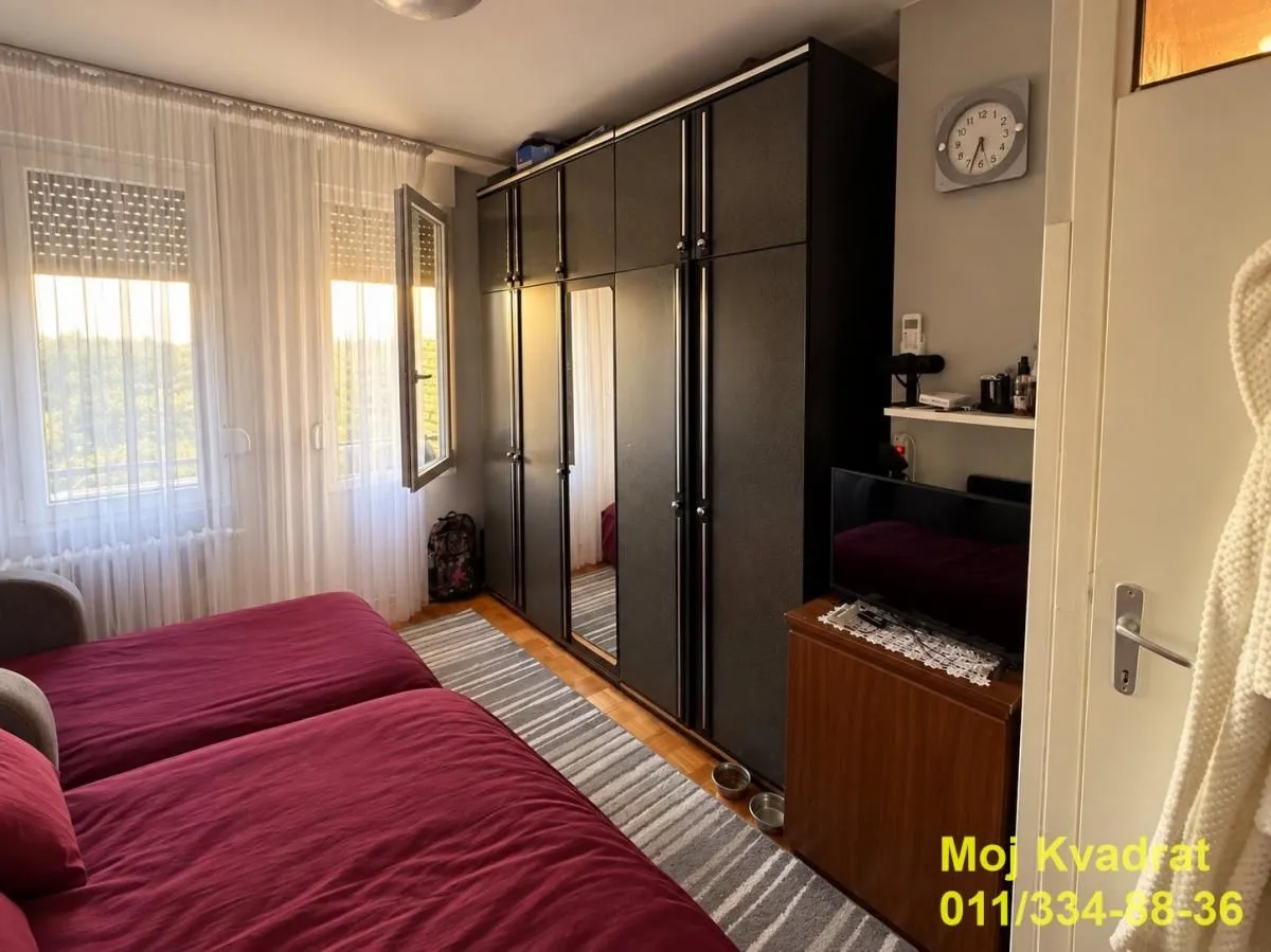 Furnished bedroom with a large wardrobe and a bed.