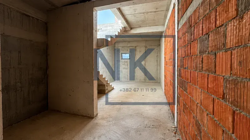 Unfinished interior under construction with stairs and concrete walls.