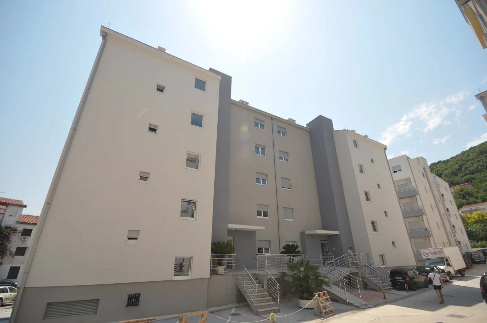 View of the exterior of the residential building with the entrance and stairs.