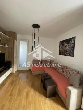 Dnevna soba sa ugaonom garniturom, TV komodom i modernim lusterom. - image 2