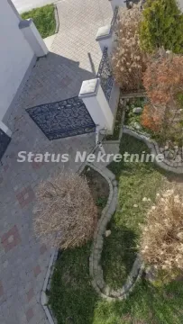 Pogled odozgo na popločano dvorište i uređeni vrt sa ogradom. - image 4